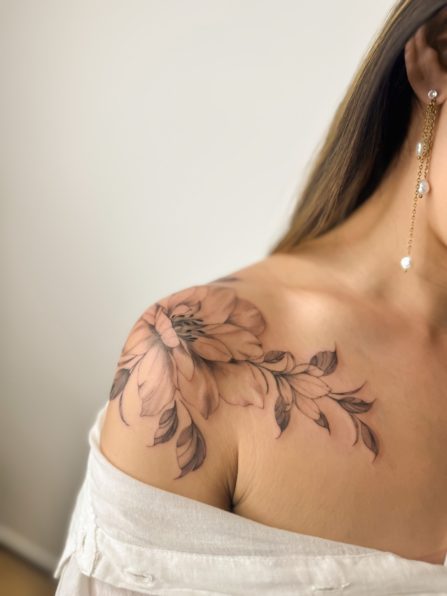 Tatouage floral fine line sur l’épaule et la clavicule réalisé à Combs-la-Ville
