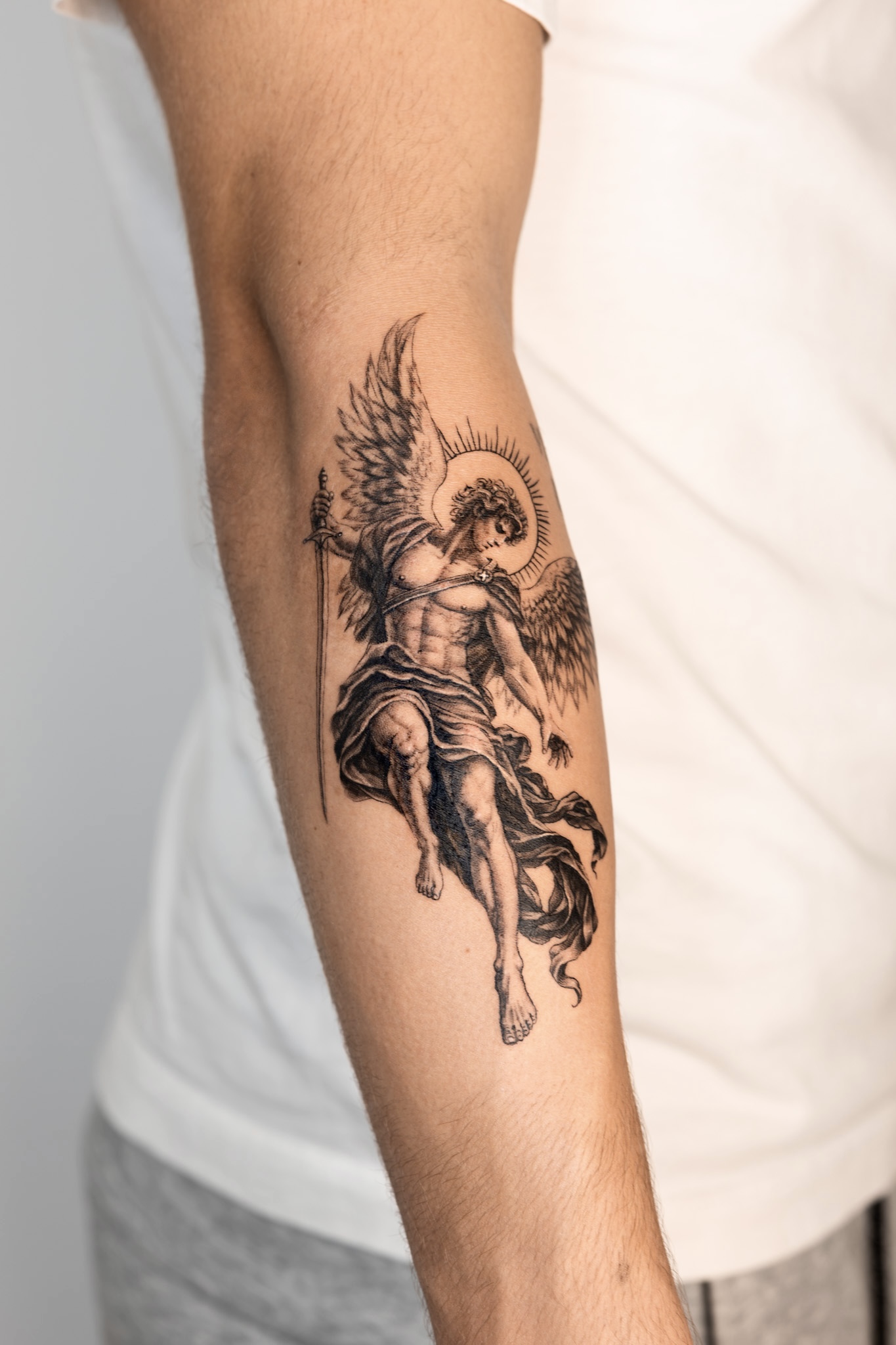 Tatouage Saint-Michel archange réaliste noir et gris sur l’avant-bras